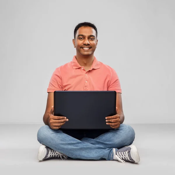 Hombre indio feliz con ordenador portátil en el suelo — Foto de Stock