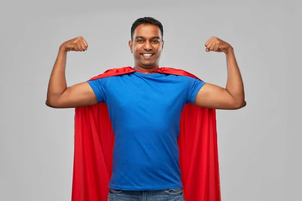 Людина-індіан у супергеройському плащі показує свою силу — стокове фото