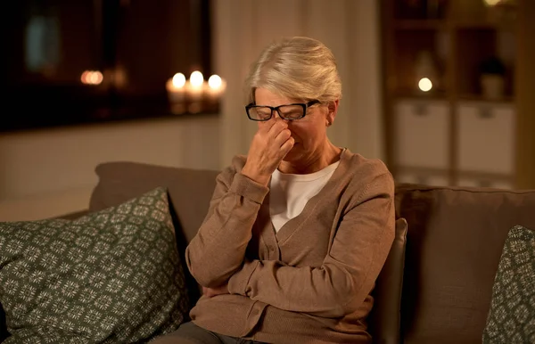 Stanca donna anziana in occhiali a casa di notte — Foto Stock