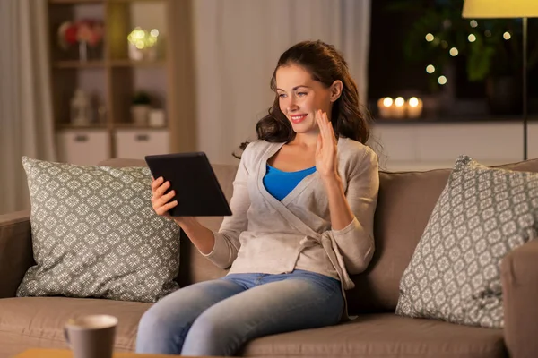 Vrouw met tablet pc met video bellen thuis — Stockfoto