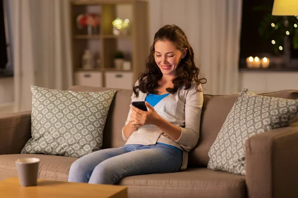 Femme avec smartphone à la maison — Photo