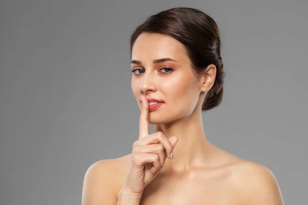 Vacker ung kvinna håller fingret på läppar — Stockfoto