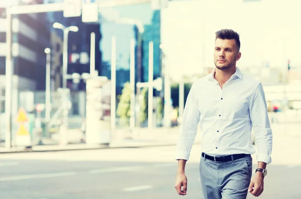 Young man walking along city street — Stock Photo, Image