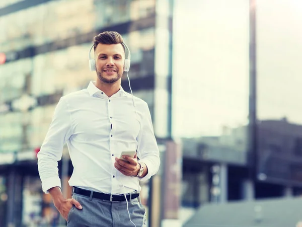 Hombre con auriculares y smartphone escuchando música — Foto de Stock