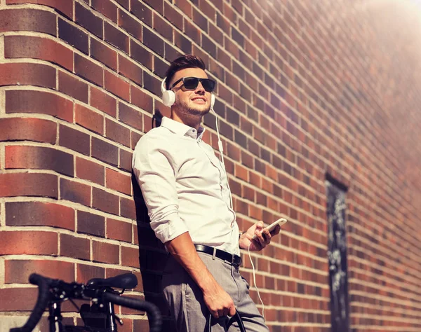 Hombre con auriculares, smartphone y bicicleta — Foto de Stock