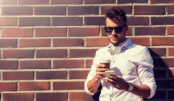 Muž s smartphone a coffee cup na ulici — Stock fotografie