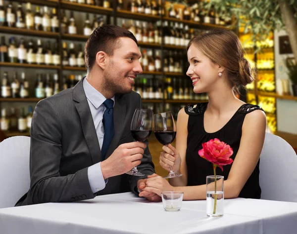 Et lykkelig par som drikker rødvin på restaurant – stockfoto