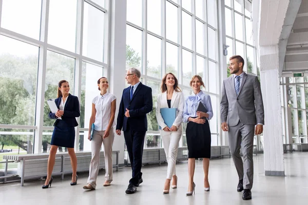 Gens d'affaires marchant le long de l'immeuble de bureaux — Photo