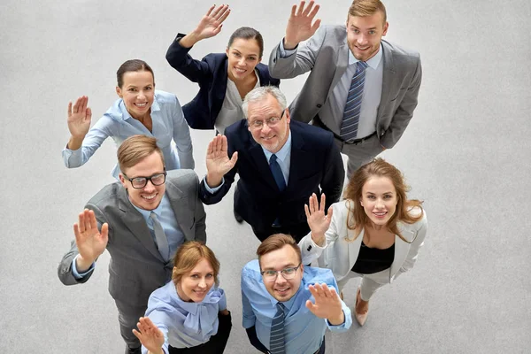 Gelukkig glimlachende zakenmensen zwaaien met handen — Stockfoto