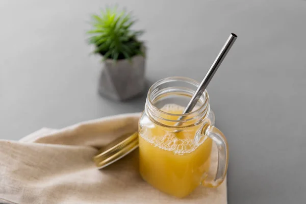 Glass mug of juice and reusable metallic straw — Stock Photo, Image