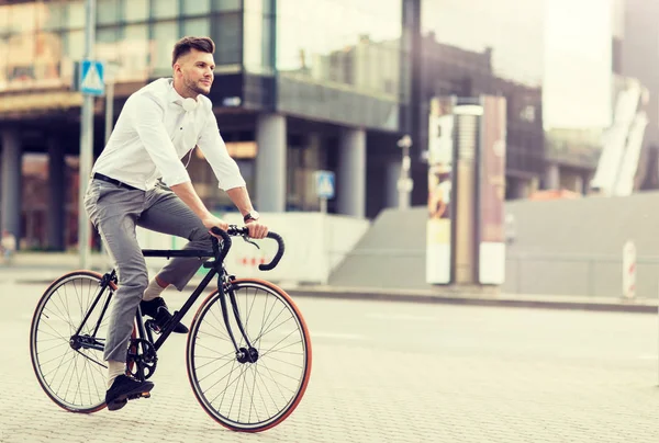 Hombre con auriculares a caballo bicicleta en la calle de la ciudad — Foto de Stock