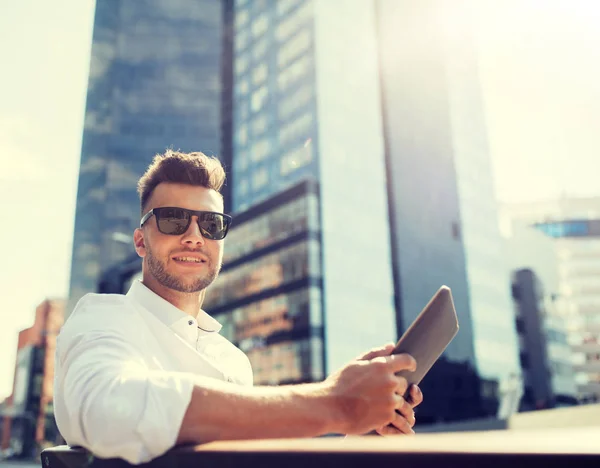 Uomo con tablet pc seduto sulla panchina della città — Foto Stock