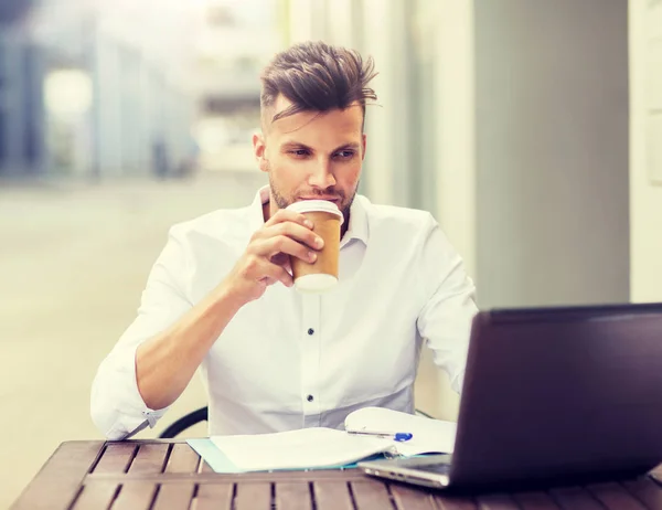 Homem com laptop e café no café da cidade — Fotografia de Stock