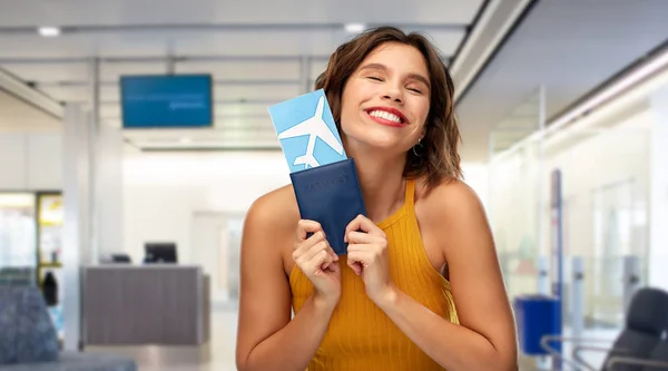 Felice giovane donna con biglietto aereo in aeroporto — Foto Stock