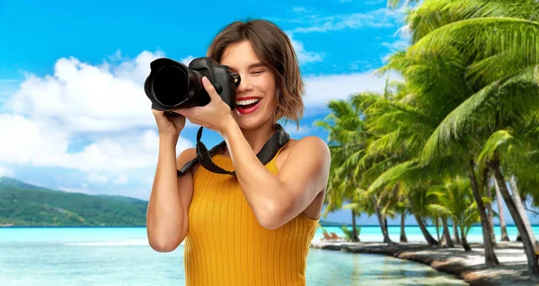 Donna felice fotografo con macchina fotografica sulla spiaggia — Foto Stock