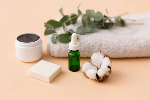 Serum, masker tanah liat, minyak dan eukaliptus pada handuk mandi — Stok Foto