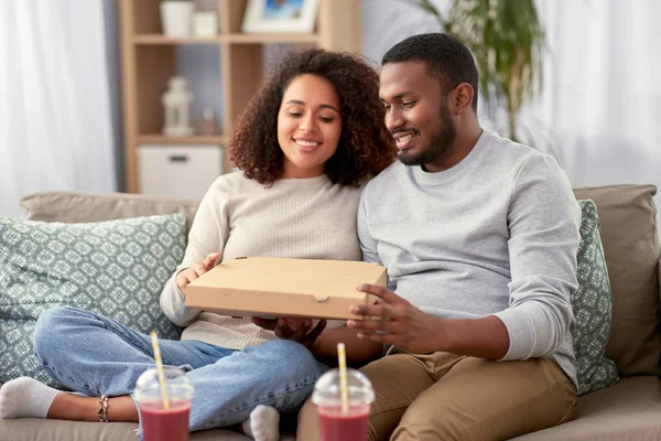 Feliz africano americano pareja comer pizza en casa — Foto de Stock