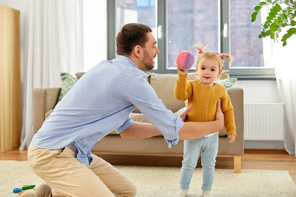 Padre e figlia bambino giocare con la palla a casa — Foto Stock