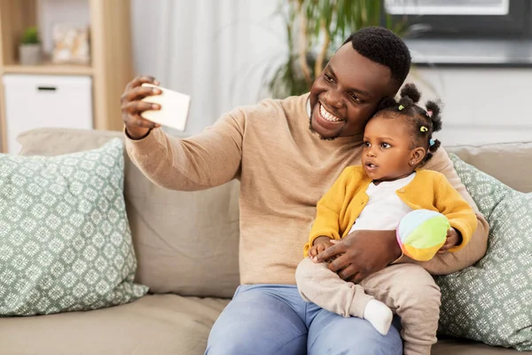 Счастливый отец с ребенком делает селфи дома — стоковое фото