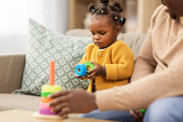 Afrikalı bir aile evde küçük kızıyla oynuyor. — Stok fotoğraf