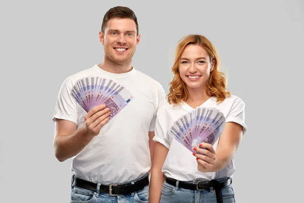 Casal feliz em camisetas brancas com dinheiro euro — Fotografia de Stock