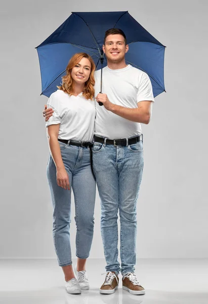 Щаслива пара в білих футболках з парасолькою — стокове фото