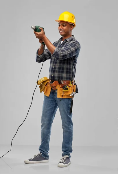 Щасливий індійський будівельник в шоломі з електричним дрилем — стокове фото