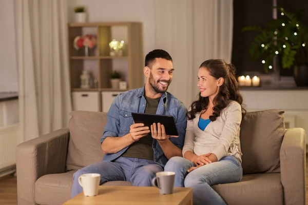 Šťastný pár pomocí počítače tablet pc doma večer — Stock fotografie
