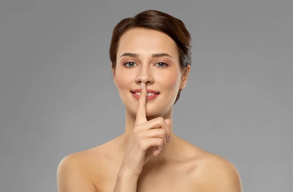Красивая молодая женщина держит палец на губах — стоковое фото