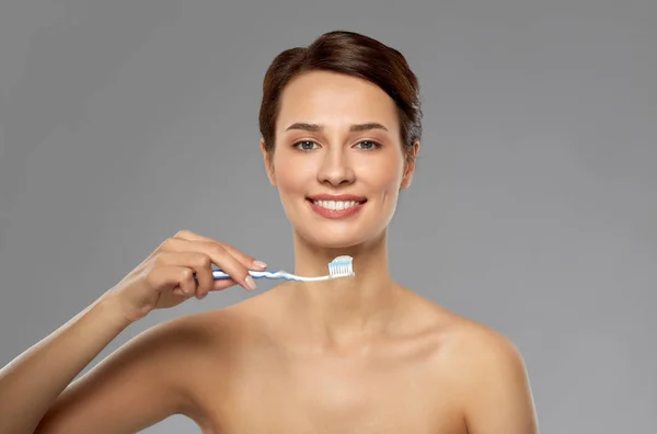 Glimlachende vrouw met tandenborstel schoonmaken tanden — Stockfoto