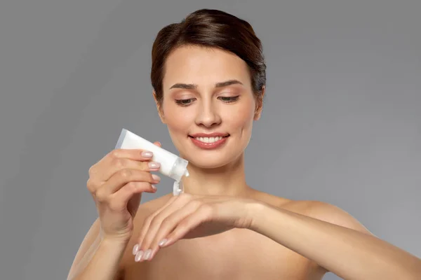 Woman applying moisturizing cream to her hand — Stock Photo, Image