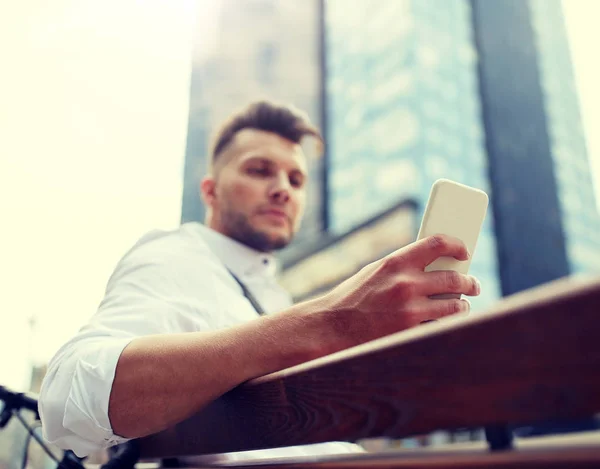 Närbild på mannen textning på smartphone i city — Stockfoto