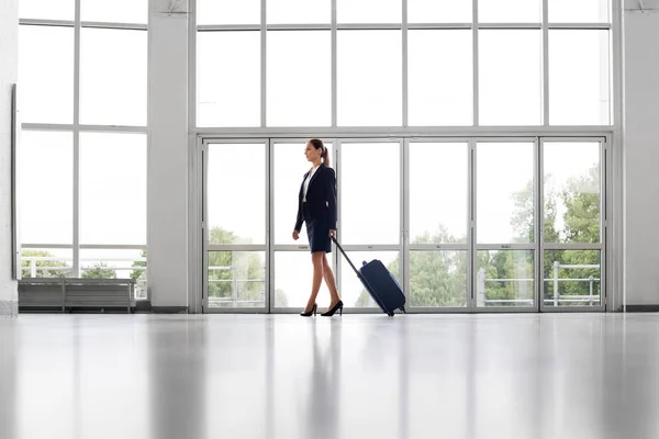 Femme d'affaires avec sac de voyage marchant le long du bureau — Photo