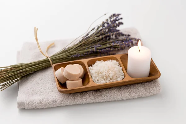 Sea salt, soap, candle and lavender on bath towel — Stock Photo, Image