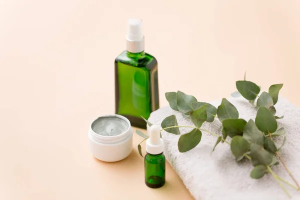 Serum, clay mask, oil and eucalyptus on bath towel — Stock Photo, Image