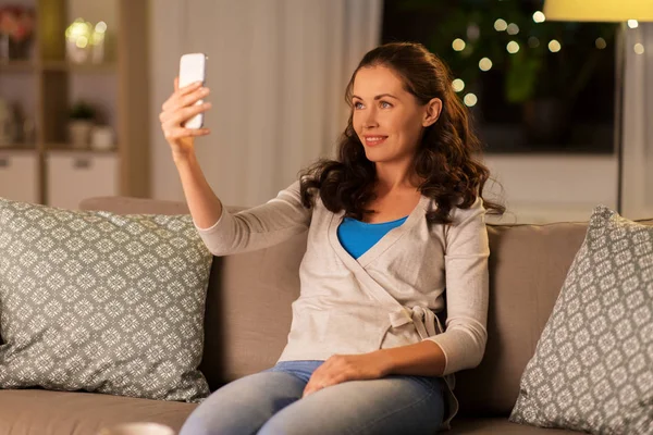 Femme heureuse prenant selfie avec smartphone à la maison — Photo