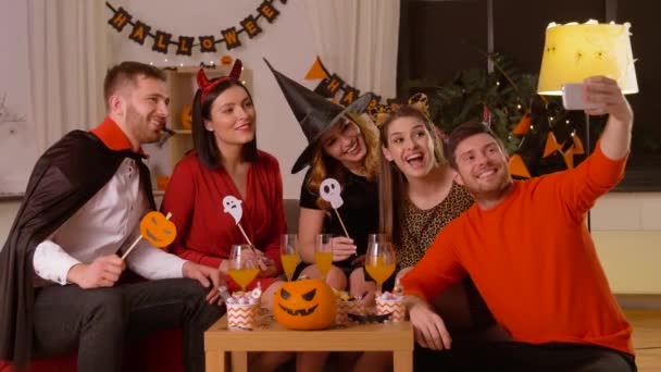 Amigos felices en disfraces de Halloween tomando selfie — Vídeos de Stock