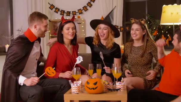 Gelukkig vrienden in halloween kostuums op home party — Stockvideo