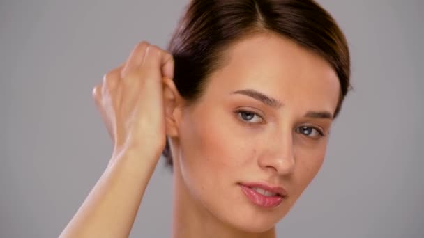 Schöne junge Frau, die ihr Gesicht berührt — Stockvideo