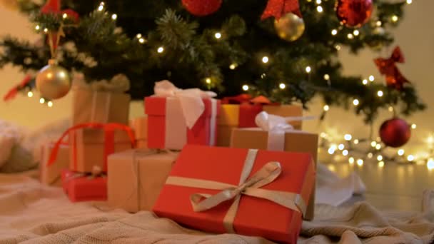 Cajas de regalo bajo el árbol de Navidad decorado en casa — Vídeos de Stock