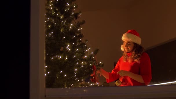 Mujer feliz decorando el árbol de Navidad con la bola — Vídeos de Stock