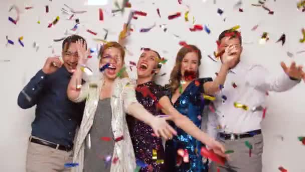 Amigos felices en la fiesta bajo confeti sobre blanco — Vídeos de Stock