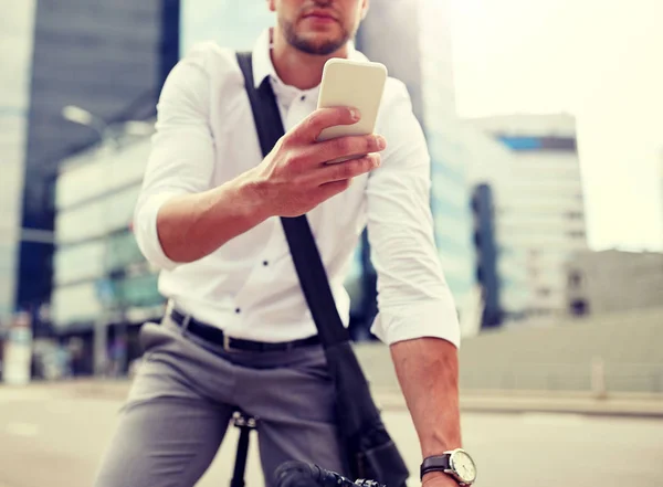 Hombre con teléfono inteligente y bicicleta de engranaje fijo en la calle —  Fotos de Stock