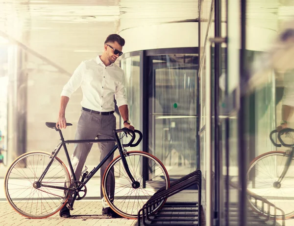 Młody człowiek parking jego rower na ulicy miasta — Zdjęcie stockowe