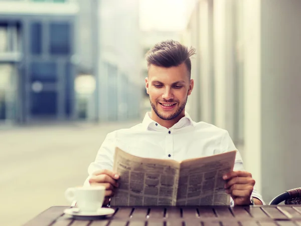Glimlachende man leest de krant in stad straat Cafe — Stockfoto