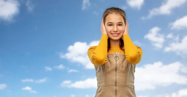 Lächelndes Teenagermädchen, das die Ohren über dem Himmel schließt — Stockfoto