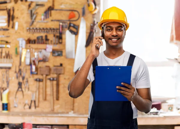 Indischer Bauunternehmer mit Klemmbrett telefoniert auf Handy — Stockfoto