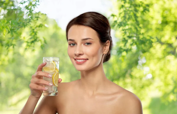 Mujer bebiendo agua con limón y hielo — Foto de Stock