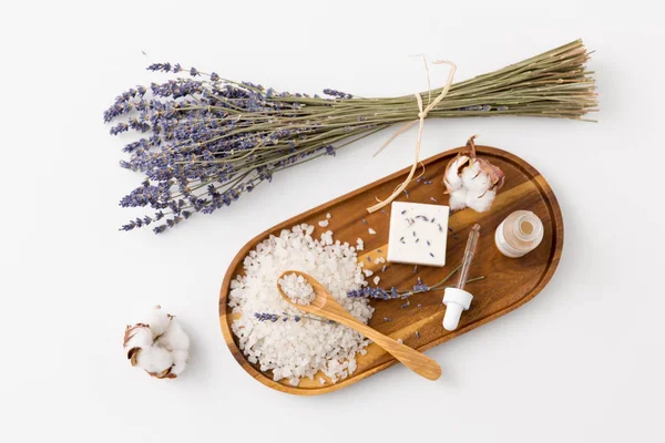 Sal marinho, sabão de lavanda e soro em bandeja de madeira — Fotografia de Stock