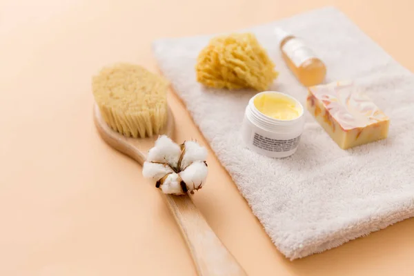 Jabón, cepillo, esponja y mantequilla corporal en la toalla de baño —  Fotos de Stock
